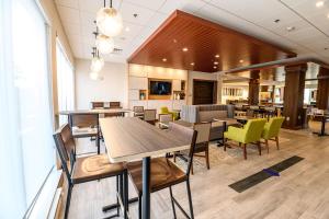 比弗克里克Holiday Inn Express & Suites Dayton East - Beavercreek的自助餐厅内带桌椅的餐厅