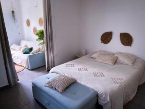 拜马欧T2 Paisible et spacieux的一间卧室配有一张大床和蓝色的搁脚凳