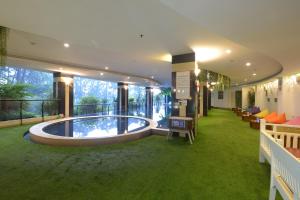 茂物茂物格兰萨维鲁酒店的一座建筑,在房间的中间有一个游泳池