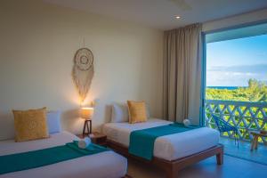 普拉亚卡门Suites Cielo y Mar的酒店客房设有两张床和一个阳台。