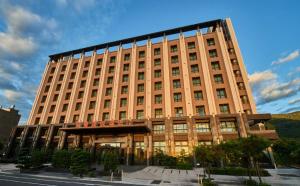 台东知本芙儷渡假酒店的一座带许多窗户的大型棕褐色建筑