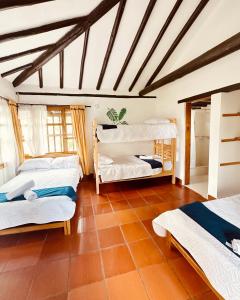 莱瓦镇Lo Nuestro - Hospedaje的带三张床和天花板的客房