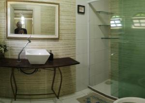 马卡埃Pousada nascente do sol的一间带水槽、镜子和淋浴的浴室