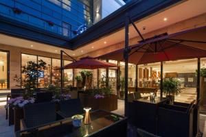 上海上海徐汇同文君亭酒店的大楼内带桌子和遮阳伞的餐厅