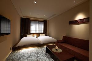 金泽Minn Kanazawa的一间卧室配有一张床和一张沙发