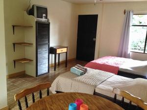 La GaritaVillas el Cenizaro的客房设有两张床、一张桌子和一台电视机。