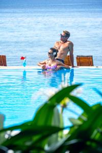维拉港布雷卡斯海滩度假酒店的坐在水中游泳池里的男人和女人