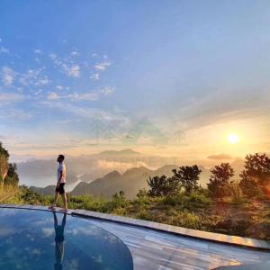 枚州县BAKHAN VIEWEST GLAMPING的站在山景无边泳池顶部的人