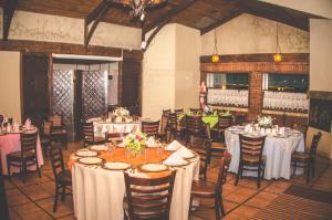 墨西卡利Hotel Siesta Real的用餐室配有桌椅和白色的桌布