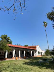 萨尔塔Finca La Secundina的一座白色的建筑,在院子里有棕榈树