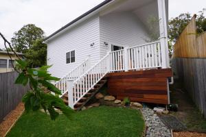 科夫斯港Seabirds Cottage的白色的房子,有楼梯通往院子