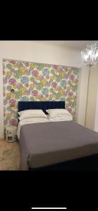 罗马VHOMETREVI的一间卧室配有一张带花卉墙壁的床