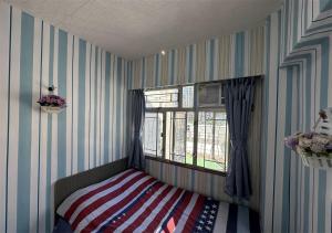香港3BR Romantic apt, 2mins MTR, 8pax的一间卧室配有一张带美国国旗毯子的床