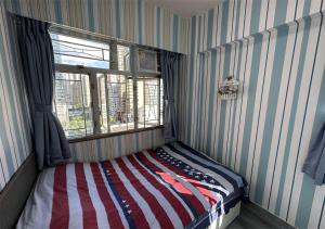 香港3BR Romantic apt, 2mins MTR, 8pax的一间设有一张带美国国旗的床的房间