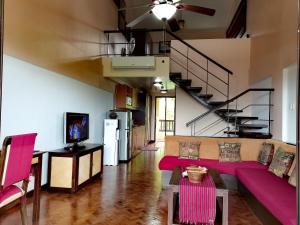 长滩岛Unit 306 Alta Vista de Boracay by David的一间带紫色沙发和楼梯的客厅