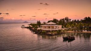 格兰高伯LUX* Grand Gaube Resort & Villas的日落时分在水中的一个岛上的度假胜地