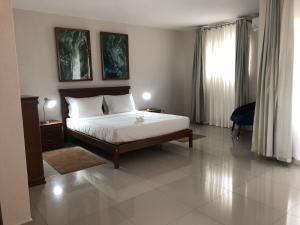 伊尼扬巴内Inhambane Hotel Escola的一间卧室设有一张床和一个大窗户