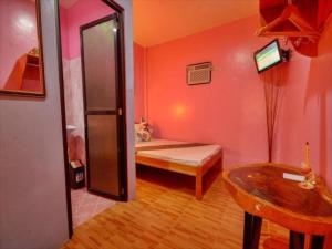 公主港OYO 622 Butterfly Totem Guesthouse的卧室配有一张床和一张桌子
