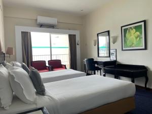 丹绒武雅Seaview Suite at Rainbow Paradise的酒店客房配有两张床和一张书桌