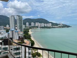 丹绒武雅Seaview Suite at Rainbow Paradise的享有海滩、建筑和大海的景色