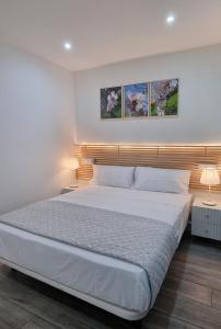 马德里Apartamento Happy Place Madrid的一间卧室配有一张带两盏灯的大型白色床。