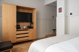 波尔沃RUNO Hotel Porvoo的一间卧室配有大电视,位于木柜内