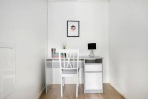 RåholtModerne leilighet - nært flyplass - lader for elbil的一张带椅子的白色书桌和一台电脑