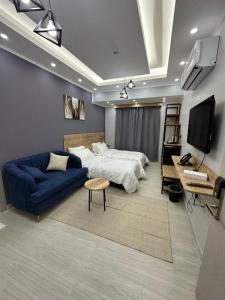 Al AmaratBlue Rose Hotel的一间卧室配有一张床和一张蓝色的沙发
