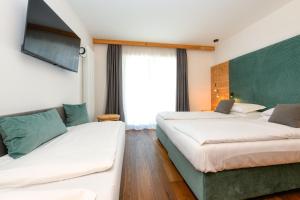 GiustinoBepy Hotel Garni的酒店客房,设有两张床和一张沙发
