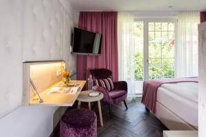 DafinsBoutiquehotel Bergvilla的酒店客房,配有一张床、一张桌子和椅子
