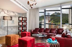 香港港岛英迪格酒店的客厅设有红色的沙发和大窗户