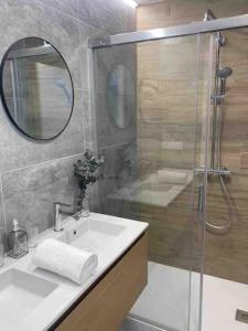 奥伦塞Casa dos Alén的浴室配有盥洗盆和带镜子的淋浴