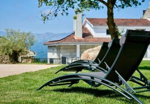 奥伦塞Casa dos Alén的两把椅子坐在房子前面的草上