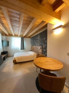利维尼奥Garni La Casetta的卧室配有一张床和一张桌子及椅子
