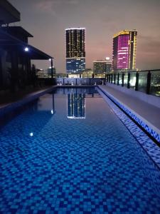 泗水Surabaya River View Hotel的一座晚上拥有城市天际线的游泳池