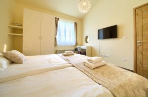 科尔尼奇Apartments ROYAL的卧室配有带毛巾的大型白色床