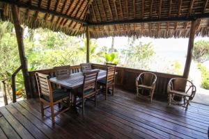 Ushongo MabaoniBaobab Beach Villa, Ushongo Beach, Pangani的木制甲板上配有桌椅