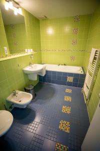 卡尔维纳斯波特酒店的浴室设有2个卫生间、水槽和浴缸。