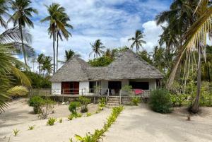 Ushongo MabaoniBaobab Beach Villa, Ushongo Beach, Pangani的棕榈树海滩上的一个小房子