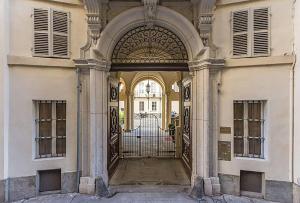 都灵TOURinTURIN appartamento in Torino centro的带有铁门的建筑物入口