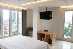 泗水Surabaya River View Hotel的配有一张床和一台平面电视的酒店客房