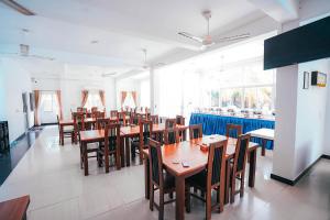 卡尔库达Sun Ray Rest House的用餐室配有木桌和椅子