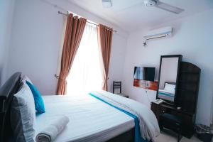 卡尔库达Sun Ray Rest House的一间卧室配有一张带镜子的床和窗户