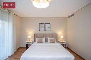 GizaPrime Select New Giza的卧室配有一张白色大床和两盏灯。