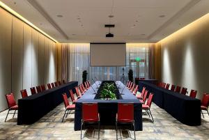 太原山西潇河新城温德姆酒店(潇河国际会议中心店)的一间会议室,配有长桌子和红色椅子