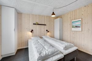 森讷维Lalandia Søndervig的木墙客房的一张床位