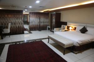 The Burj Ghazanfar in Mazar-e Sharif的一间卧室配有一张大床和一张沙发