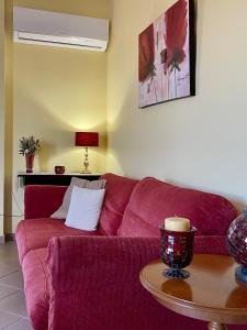 哈尔基斯Lefkandi Family House的客厅里一张红色的沙发,配有桌子