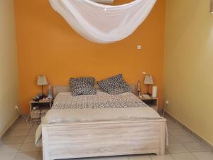 萨利波图尔Magnifique Villa Riad avec piscine proche plage的卧室配有一张床铺,上面有白色窗帘