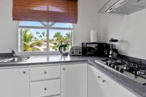 棕榈滩Beach Walk Residences的厨房配有白色橱柜、水槽和窗户。